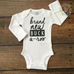 a white baby bodysuit that says brand new buck a - boo