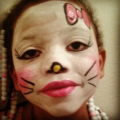 a girl with her face painted to look like a cat