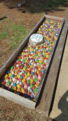 a bench made out of bottle caps with a cake in the middle on it's side