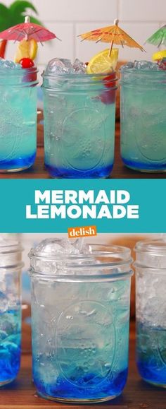 several jars filled with blue liquid sitting on top of a wooden table next to an umbrella