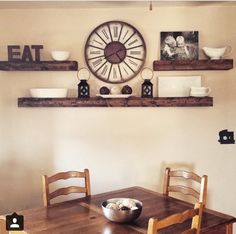 a wooden table with two chairs and a clock on the wall