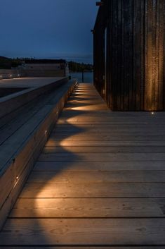 a wooden walkway with lights on it at night