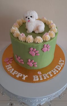 a birthday cake with a dog and paw prints on the top, sitting on a table