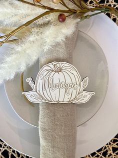 a white plate topped with a paper cut out of a pumpkin on top of a table