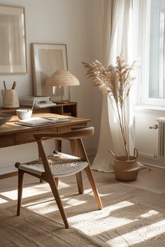 a desk with a chair, lamp and pictures on the wall