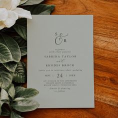 wedding stationery with flowers and greenery on wooden table