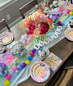 a table set for a baby shower with plates, napkins and flowers on it