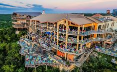 an aerial view of a building with many people on the balconys and in the trees