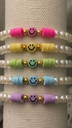 four bracelets with smiley faces on them