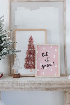 a small christmas tree sitting on top of a wooden shelf next to a framed photo