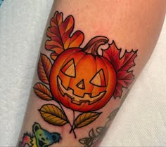 a tattoo with a pumpkin and leaves on it