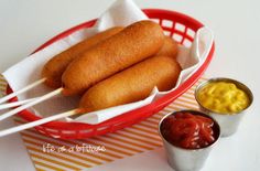 there are several pictures of hot dogs and mustard in the basket, along with some ketchup