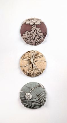 three different types of buttons on a white surface, each with an image of a tree