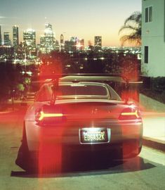 a red sports car parked in front of a city skyline