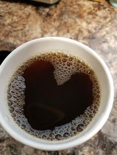 a white cup filled with liquid on top of a counter