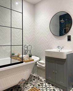 a bathroom with a sink, mirror and bathtub in the middle of the room