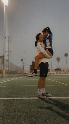 two people are hugging on a tennis court