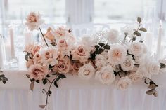 flowers and candles on a table in front of a window