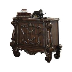 an ornate wooden cabinet with a dog figurine on top