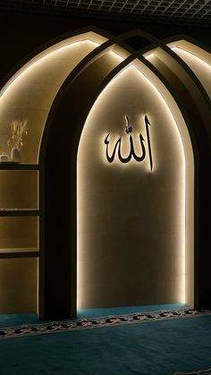 an illuminated entrance to a building with arabic writing on the wall and lights above it