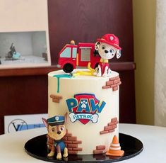 a birthday cake with a dog and firetruck on top