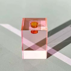 a pink and orange object sitting on top of a white floor next to a window