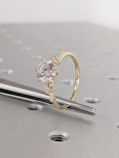 a diamond ring sitting on top of a piece of metal next to a pair of scissors