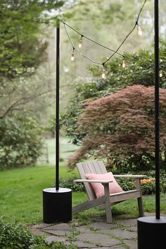 a wooden bench sitting next to a light pole on top of a lush green field