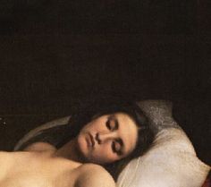 a naked woman laying on top of a bed next to a red pillow and blanket