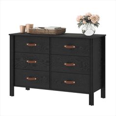 a black dresser with drawers and flowers on top