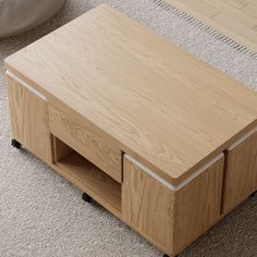 a wooden coffee table with two drawers on it's sides, sitting on the carpeted floor