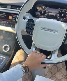 a woman is holding the steering wheel of a car