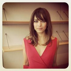 a woman in a red dress is posing for the camera