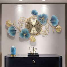 a wall clock with blue flowers and gold leaves on it's face in a living room