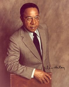 a man in a suit and tie holding a brown briefcase with his right hand on the handle