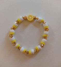 a yellow and white beaded bracelet with an orange slice