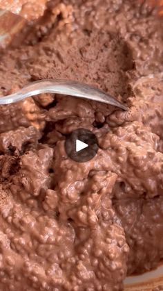 a spoon sticking out of a bowl filled with chocolate pudding