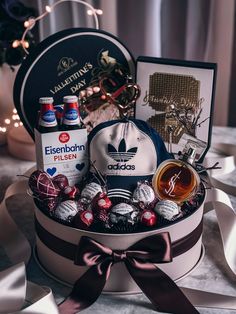 a hat and other items in a gift box on a table with lights behind it