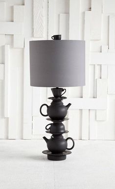 a lamp that is sitting on top of a table with some cups in front of it