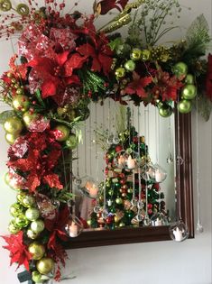 a mirror decorated with christmas ornaments and greenery