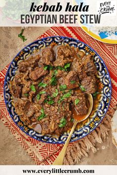 a blue and white bowl filled with beef stew on top of a red table cloth