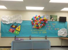 there is a bulletin board in the classroom with balloons on it and other decorations hanging from the wall