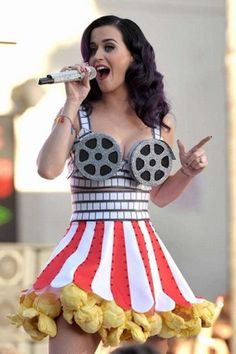 a woman in a costume singing into a microphone