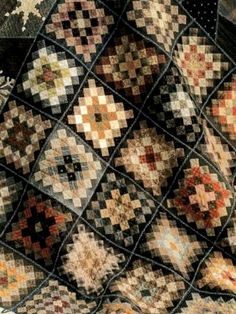 an old quilt with many different colors and designs on it's sides, including the center