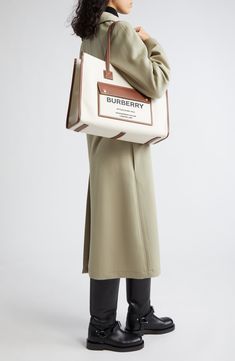 Burberry's Horseferry logo is stamped on the front pocket of this versatile tote that has a casual feel in neutral-hued canvas and topstitched leather trim. Open top Top carry handles Exterior magnetic-flap pocket Interior zip pocket Canvas with leather trim Made in Italy Designer Handbags Cream Bags With Leather Trim For Work, Cream Leather Trim Bag For Work, Beige Workwear Bag With Canvas Lining, Cream Workwear Bags With Leather Trim, Canvas Leather Tote, Natural Tan, Top Top, Open Top, Canvas Leather