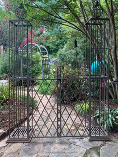 an iron gate in the middle of a garden