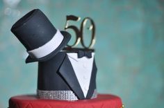 a cake with a top hat and bow tie on it's side that says 50