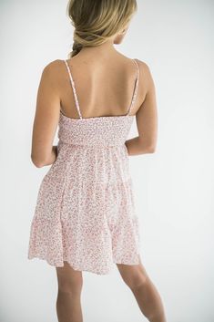 Elevate your look with our Dylan mini dress, a perfect blend of elegance and summer fun. This dress features a flattering twist front design and playful tiered layers. It has adjustable spaghetti straps that ensure a personalized fit, while the smocked back provides comfortable stretch and support. Ideal for both casual outings and special occasions, this mini dress is your go-to choice for a chic and effortless look. Size Chart Features: mini length twist front v-neck design smocking adjustable spaghetti straps lined fabric content: 100% polyester model is wearing a small. Height 5'7" Bust 34", Waist 25", Hip 36" Denim Accessories, Twist Front, Front Design, Dress Romper, Neck Designs, Bottoms Pants, Short Tops, Summer Fun, Spaghetti Strap