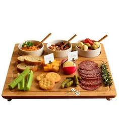 a wooden platter filled with different types of food and snacks on top of it