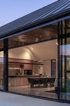 an open living room and dining area with sliding glass doors on the side of the house